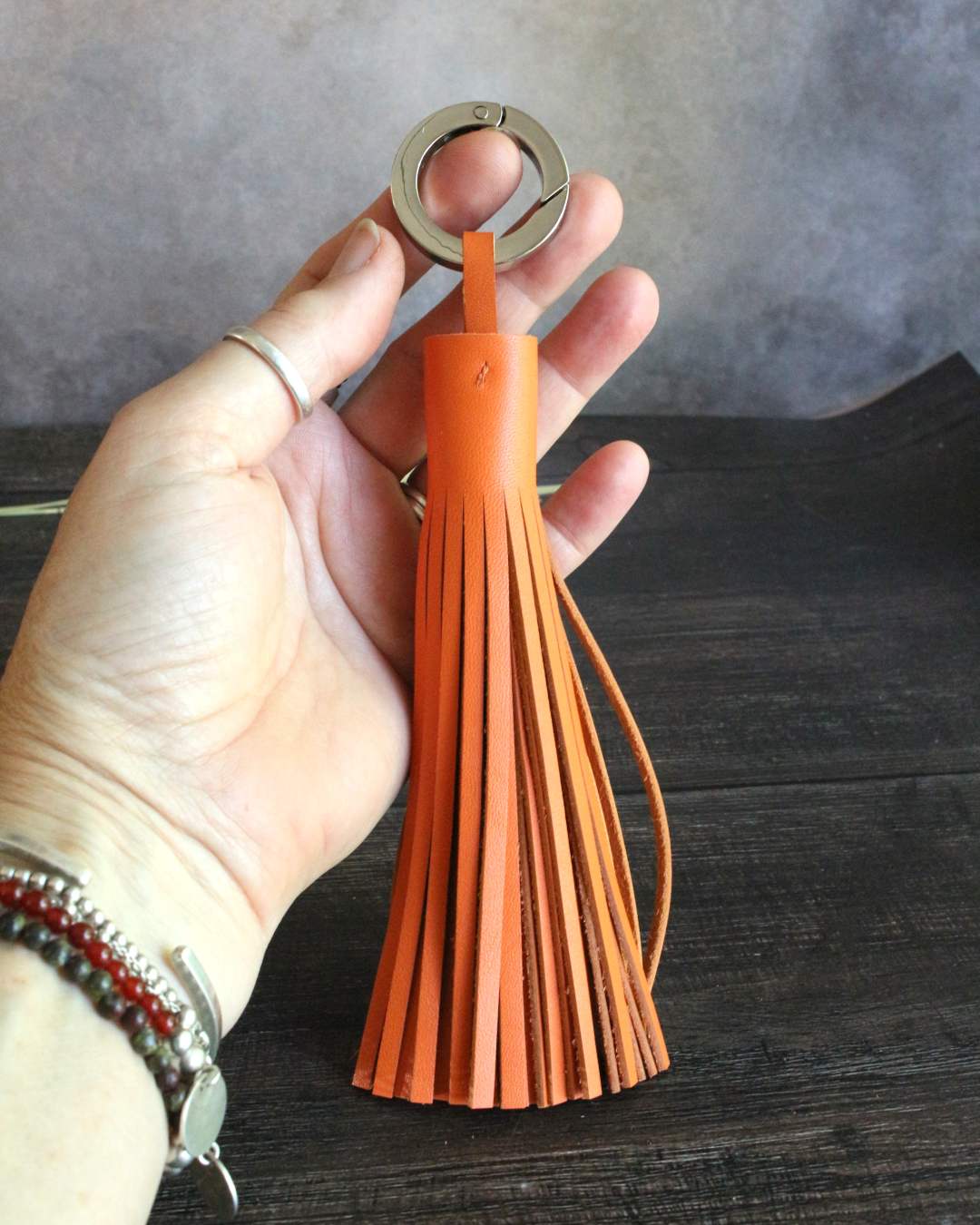 Porte-clef-pompon-en-cuir-orange-hermes Porte clefs en cuir orange Hermes de forme pampille ou pompon long avec un anneau nickelé qui s'ouvre comme un mousqueton