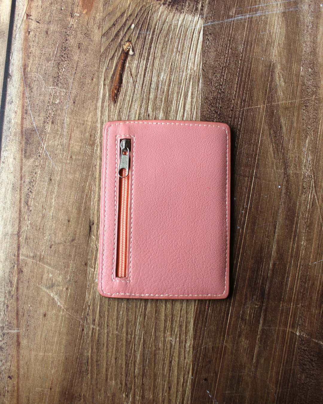 Porte-carte-artisanal-en-cuir-rose Porte cartes en cuir rose avec une poche au dos zippée