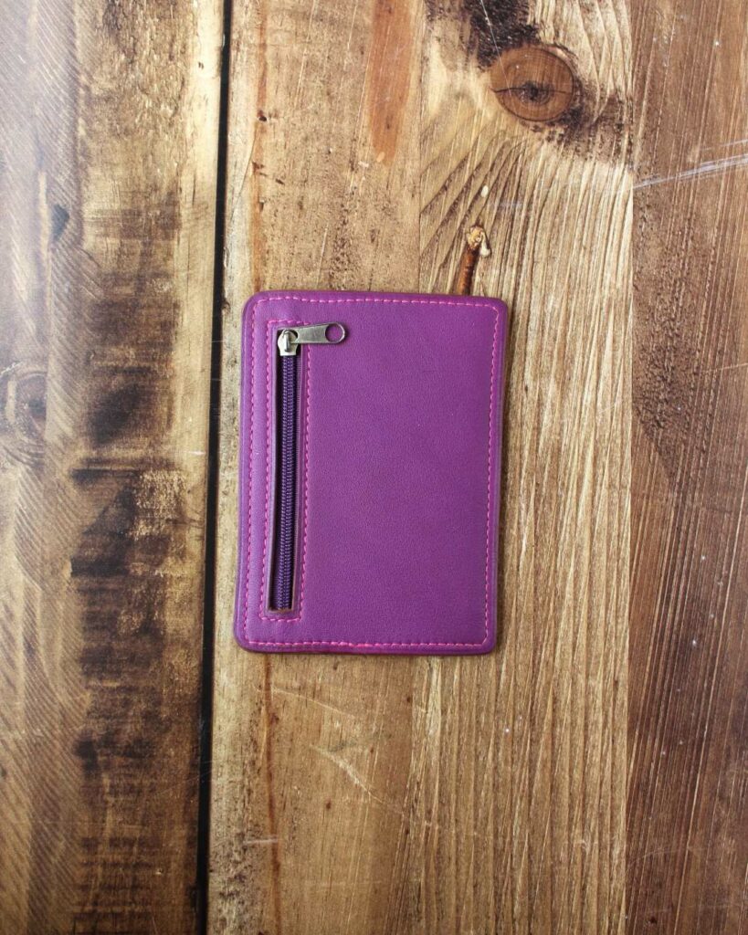 Porte cartes minimaliste en cuir violet avec une poche au dos fermée par un zip pour les billets
