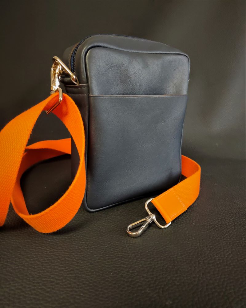 Un sac pochette homme en cuir bleu souple bandoulière sangle orange