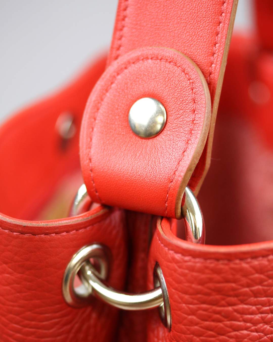 Sac-a-main-rouge-anse-cuir Sac à main rouge avec une anse fixée par des boutons pression
