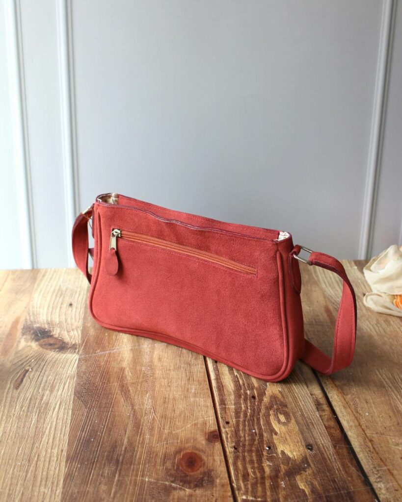 Sac porté à l'épaule en cuir velours terracotta avec une poche extérieure fermée pas un zip